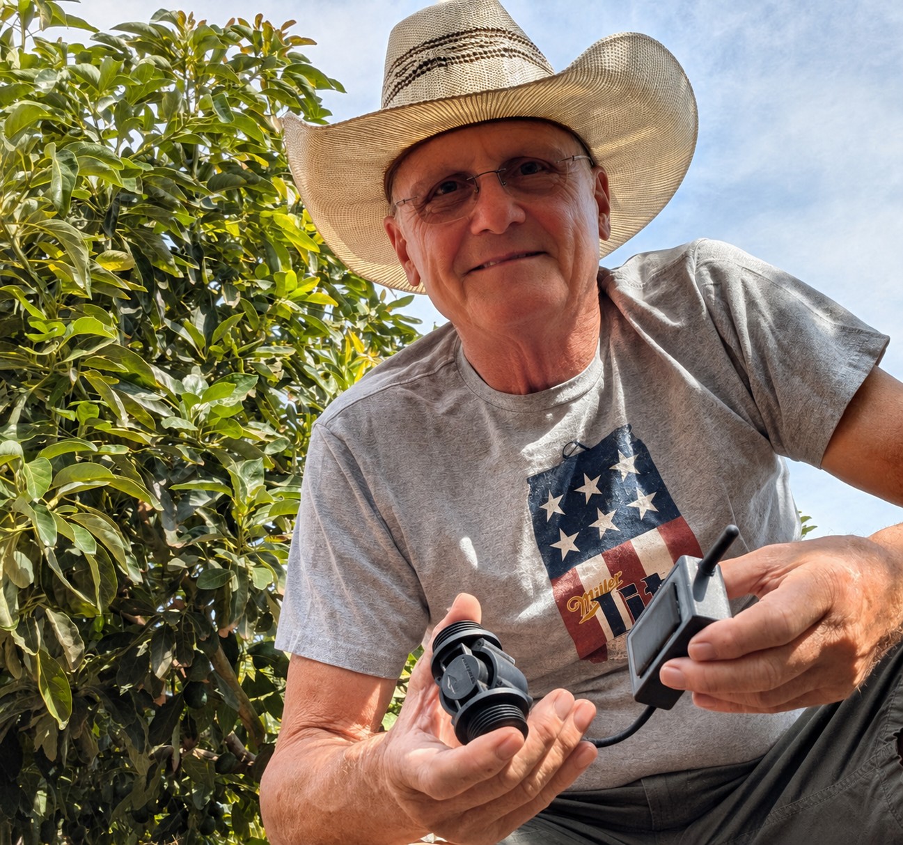 Hans Klein in the grove holding an iFlow Aware flow sensor