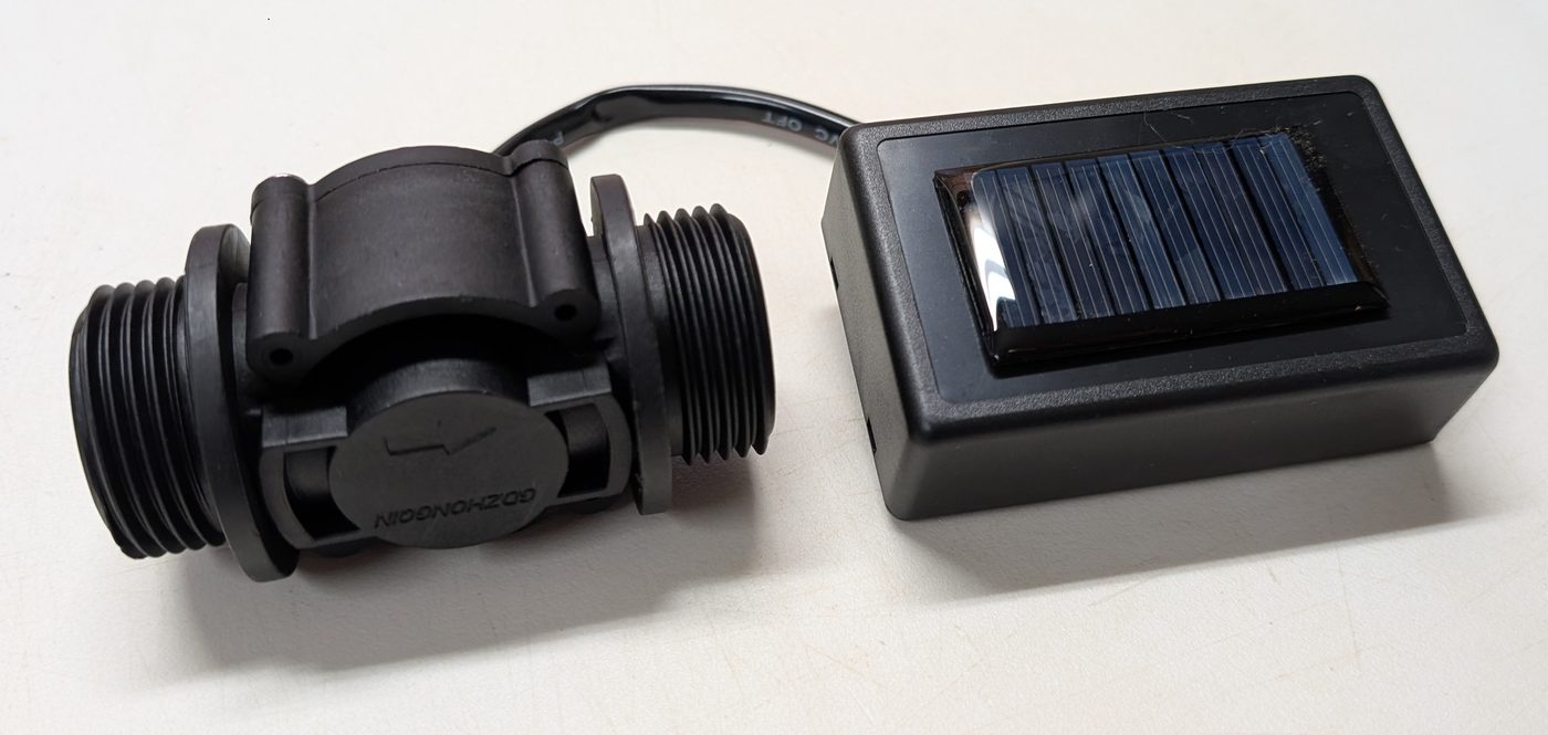 The flow sensor and solar-powered transmitter on a white background