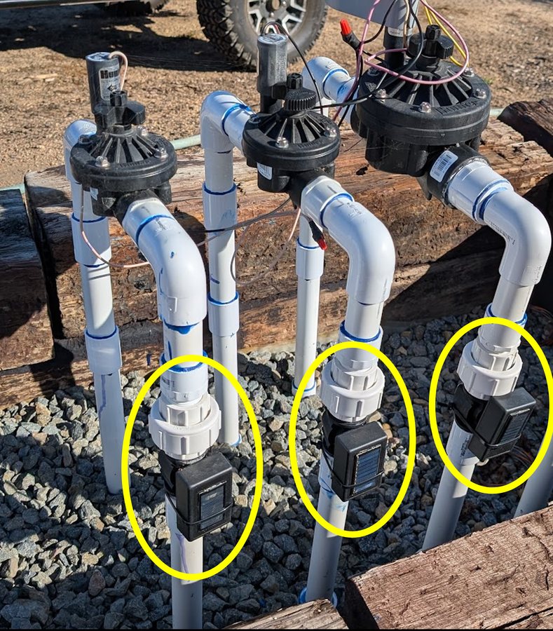 Three solar-powered sensors installed by the irrigation valves in a working vineyard